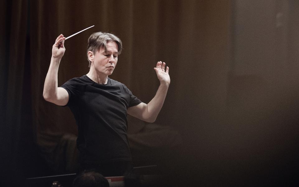 Esa-Pekka Salonen on stage, holding a baton, wearing a black t-shirt