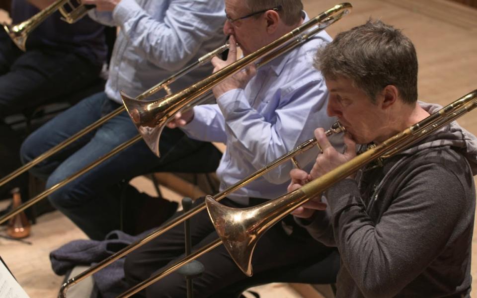 Philharmonia trombones rehearsing on stage