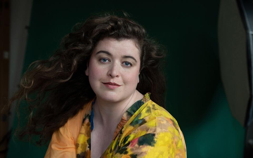 Jess Dandy wearing a yellow floral shirt, looking into the camera