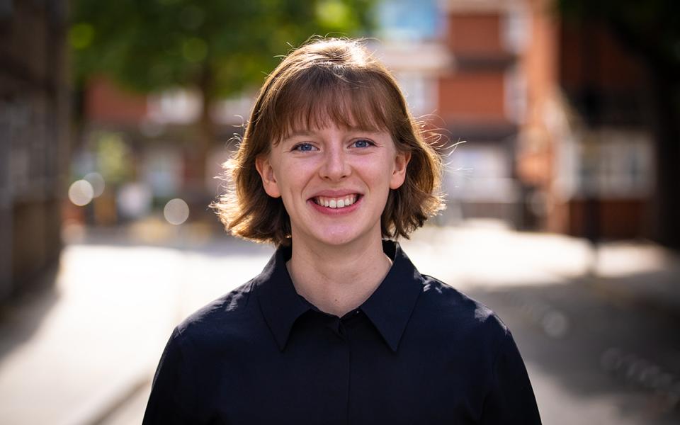 Isabella Ward, Philharmonia Instrumental Fellow, smiling at the camera outside Philharmonia office