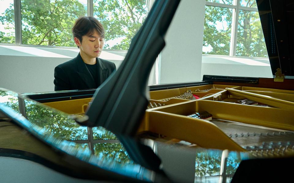 Seong-Jin Cho sat at the piano looking downwards. The image largely shows the inside of the piano.