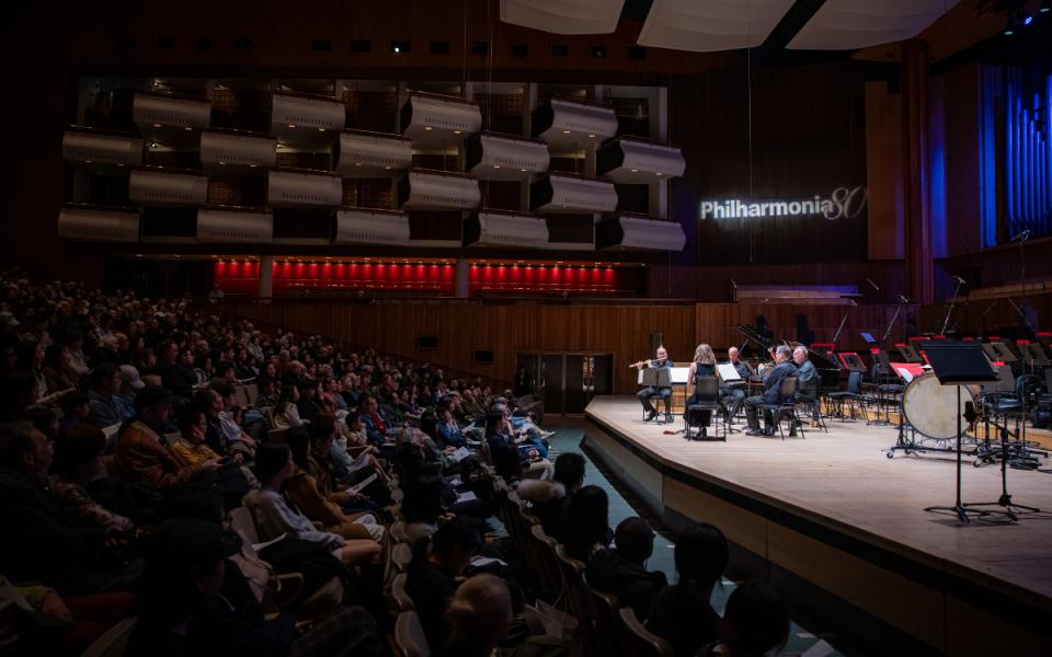 Philharmonia Chamber Players, led by Principal Flute Samuel Coles, photographed from the side in front of a full audience at the Royal Festival Hall