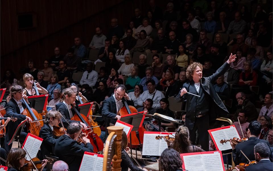 Santtu conducting the Philharmonia with his arms outstrech ed