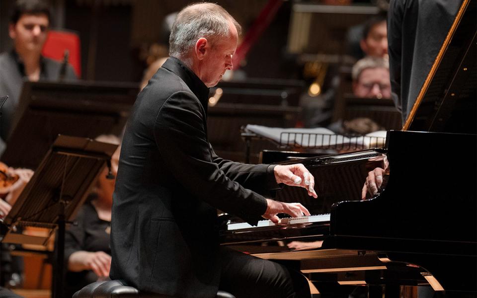 Side profile shot of Stephen Osbourne playing the piano