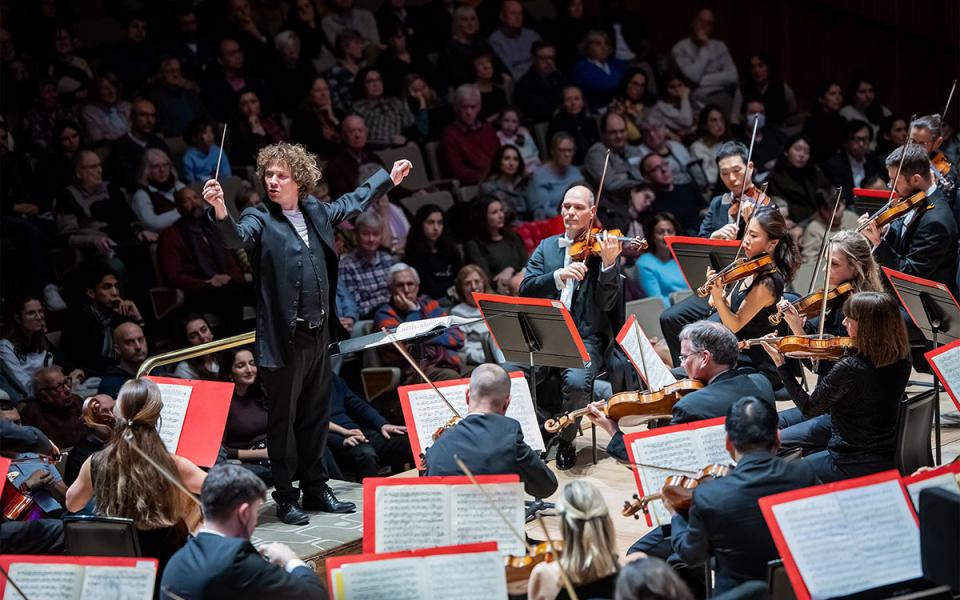 Santtu conducting the Philharmonia with his arms outstretched