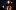 Sol Gabetta against a black background playing her cello